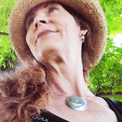 Portrait einer Frau mit langen Haaren und Strohhut